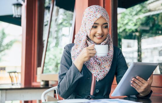 Young businesswoman on a coffee break. Using tablet computer